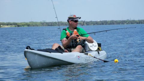 1953 Ford Mainline - A man enjoys a day of fishing from his kayak on a calm lake.