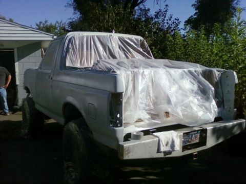 1989 Ford Bronco - This 1989 Ford Bronco is covered in plastic sheeting, likely for painting or protection.