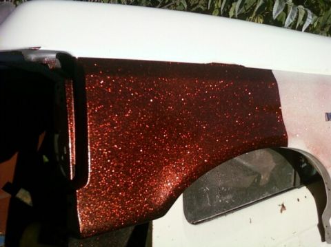1989 Ford Bronco - A vehicle's body panel is shown with a unique dark red glitter paint job.