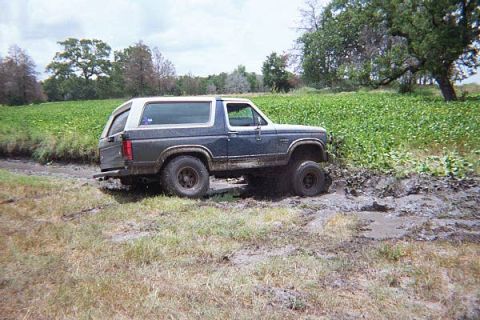 1986 Ford Bronco - This 1986 Ford Bronco navigates a muddy terrain, its off-road capabilities.