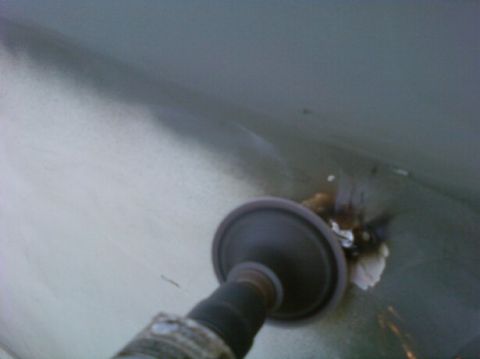 1989 Ford Bronco - Tool grinding rust from a vehicle's body panel during repair work.