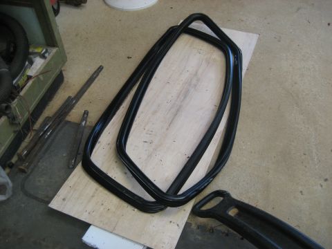 1978 Ford Bronco - Two black rubber window seals are shown on a wooden surface, with a black handle nearby.
