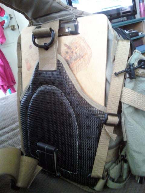 1984 Ford Bronco - A tan backpack with a clipboard secured to its front, showing a partial drawing.