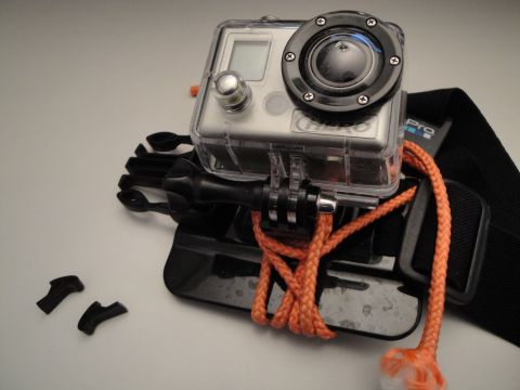 1993 Ford Taurus - A close-up of a GoPro camera and its mounting accessories, including a strap and lanyard.