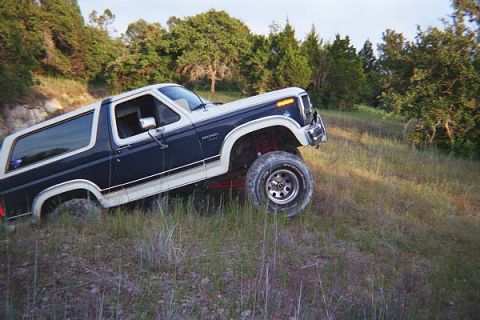 1986 Ford Bronco - This Ford Bronco appears to be from the early 1980s, not 1986, as it navigates uneven terrain.