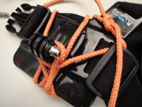 1993 Ford Taurus - A close-up view of a GoPro camera mount, intricately tied with bright orange rope, showing the attachment mechanism.