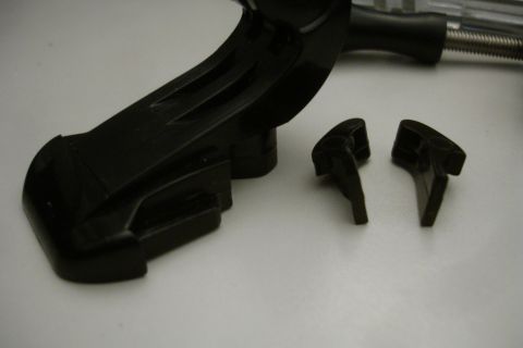 1993 Ford Taurus - Close-up of a black plastic automotive component and two small detached clips.