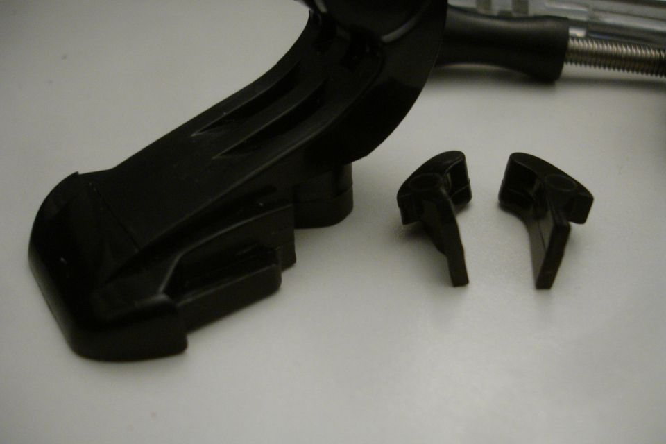 Black plastic car part with two smaller detached pieces