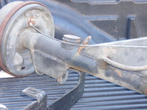 1988 Ford Bronco - A close-up view of a vehicle's rear axle assembly, a drum brake system.