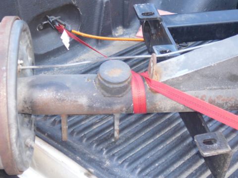 1988 Ford Bronco - A rear axle assembly is secured with red straps inside a truck bed.