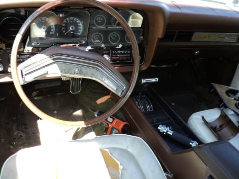 1974 Ford Elite - Interior view of a 1974 Ford Elite, a brown dashboard and center console, with a drill on the floor.