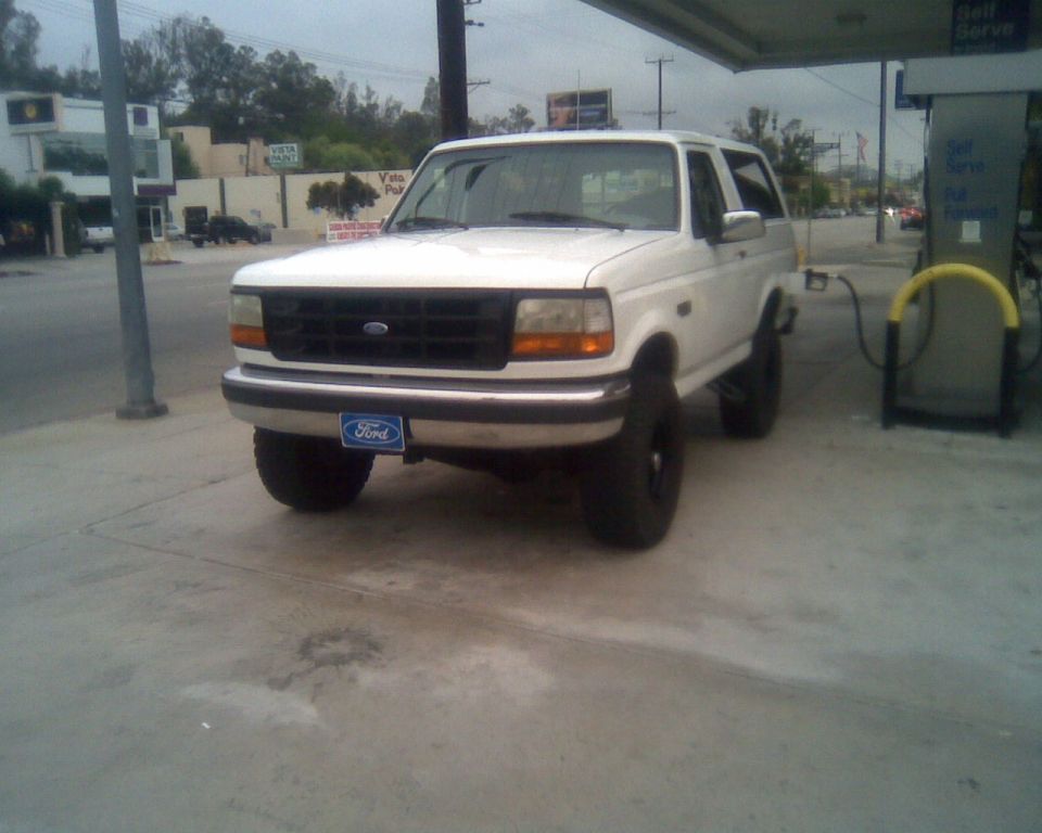 White full-size Ford Bronco SUV at a gas station, front three-quarter view