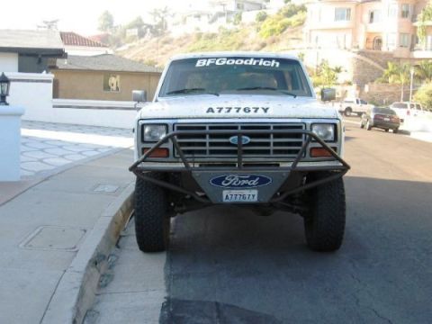 1986 Ford Bronco - This white Ford Bronco features a custom front bumper and BF Goodrich branding.
