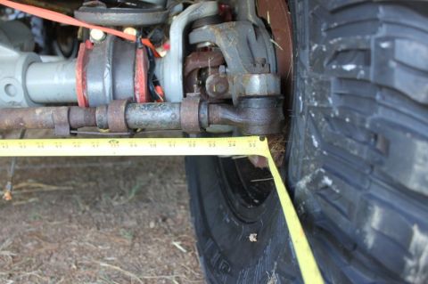 1987 Ford Bronco - A close-up view of a vehicle's suspension system and tire, with a measuring tape indicating dimensions.