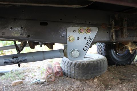 1987 Ford Bronco - Close-up view of aftermarket suspension components attached to a vehicle's frame.