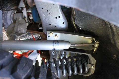 1987 Ford Bronco - Undercarriage view of suspension components, including a shock absorber and coil spring, with visible branding text.
