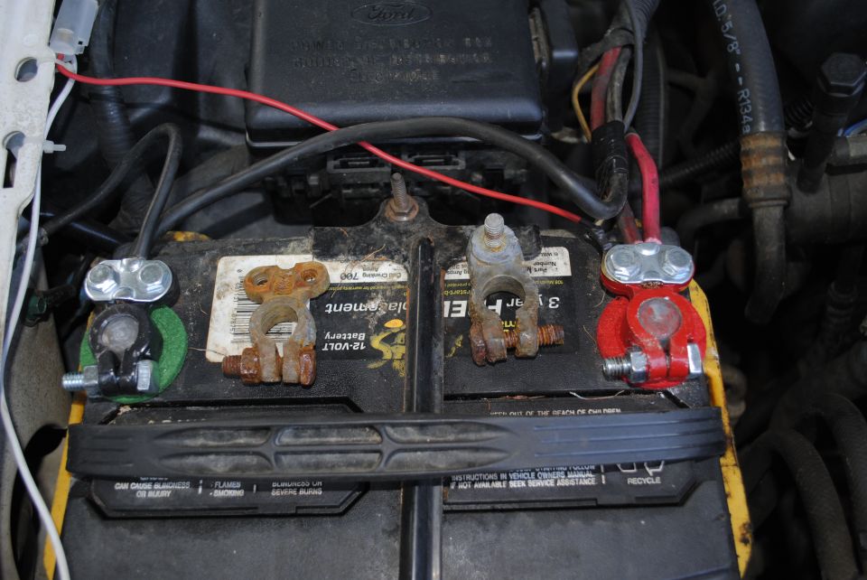 Car battery with red and silver terminals and rusty connectors