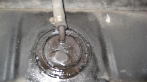 1968 Ford Ranchero - Close-up view of a fuel tank's sending unit access hole, showing a connected fuel line.