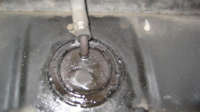 Fuel tank sending unit access hole with a fuel line attached