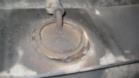 1968 Ford Ranchero - Close-up of a vehicle's fuel filler neck assembly, indicating wear and tear.