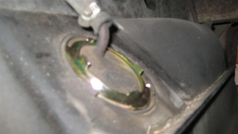 1968 Ford Ranchero - Close-up of a fuel tank's sending unit access hole, showing a connected hose.