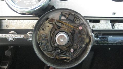 1968 Ford Ranchero - The exposed wiring and components of a vehicle's steering column are visible, along with a gauge and car stereo.