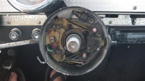 1968 Ford Ranchero - The interior of a vehicle's steering column is shown with its cover removed, revealing complex wiring and mechanical parts.
