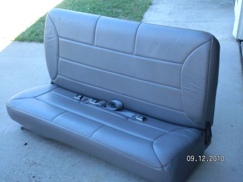 1996 Ford Bronco - Rear bench seat with integrated seatbelts, photographed outdoors.