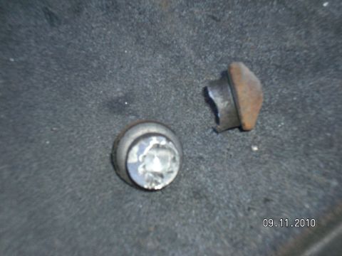 1996 Ford Bronco - Close-up of two metal fasteners on a dark, textured surface with a date stamp.