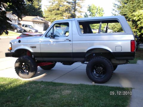 1996 Ford Bronco - This lifted 1996 Ford Bronco is shown from the side, large off-road tires and a two-tone paint scheme.