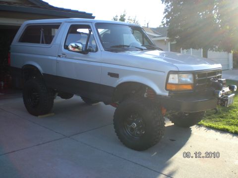 1996 Ford Bronco - This lifted 1996 Ford Bronco is parked in front of a house with a garage.