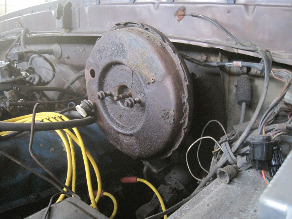 Rusty brake booster with yellow spark plug wires and wiring harness