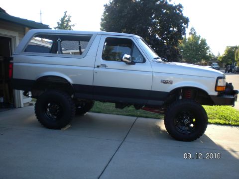 1996 Ford Bronco - This lifted 1996 Ford Bronco is shown from the side, large off-road tires and a silver exterior.