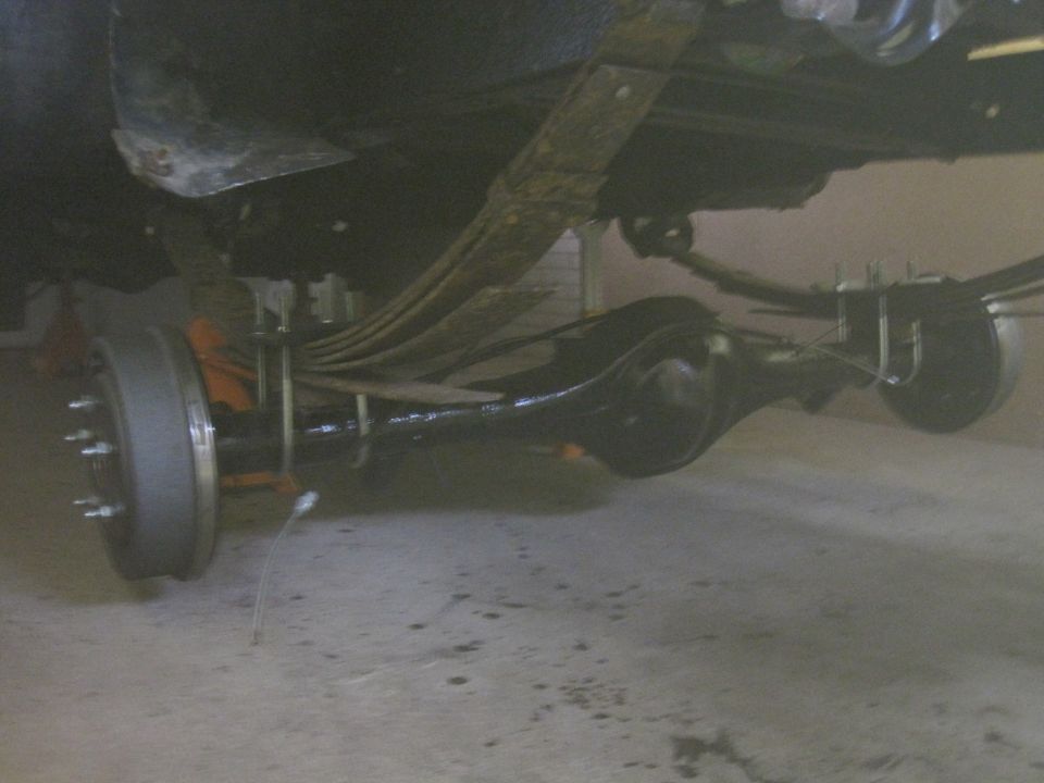 Rear axle with leaf springs and drum brake assembly