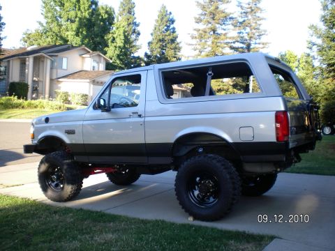 1996 Ford Bronco - This lifted Ford Bronco is shown from the rear three-quarter angle, parked on a driveway.