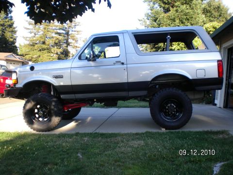 1996 Ford Bronco - This lifted 1996 Ford Bronco shows off its side profile, highlighting its modified suspension and off-road tires.