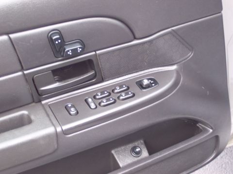2001 Ford Crown Victoria - Close-up of a car's interior door panel, showing the window and seat controls.