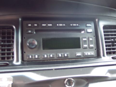 2001 Ford Crown Victoria - The dashboard of a vehicle shows the radio controls and air conditioning vents.