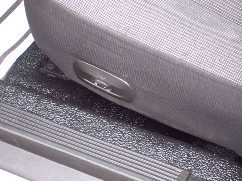 2001 Ford Crown Victoria - A power seat adjustment control is visible on the side of a car's fabric seat.