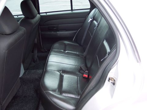 2001 Ford Crown Victoria - The rear interior of a sedan, black leather seats and black carpeting.