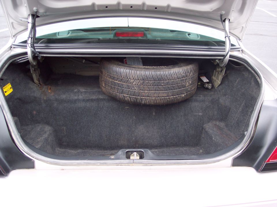 Open trunk of a 2001 Ford Crown Victoria showing spare tire and jack