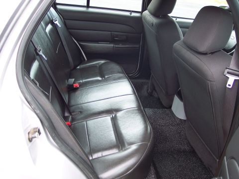 2001 Ford Crown Victoria - Rear interior view of a 2001 Ford Crown Victoria, showing the black leather seats and carpeting.