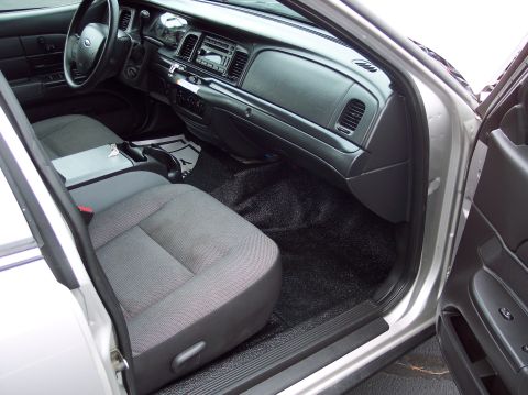 2001 Ford Crown Victoria - The interior of a Ford Crown Victoria shows the driver's side seat, dashboard, and floor mats.