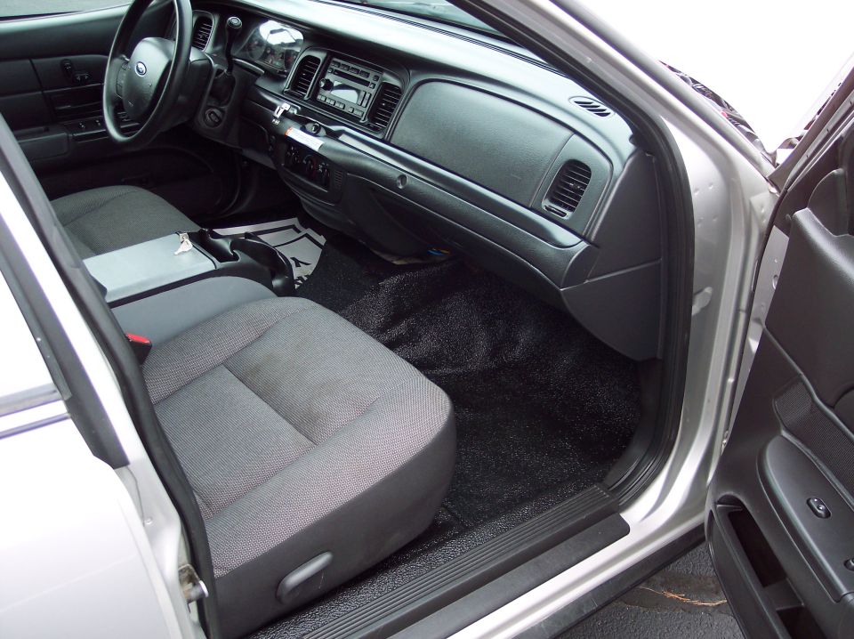 Interior shot of a Ford Crown Victoria, showing the driver's seat, dashboard, and center console