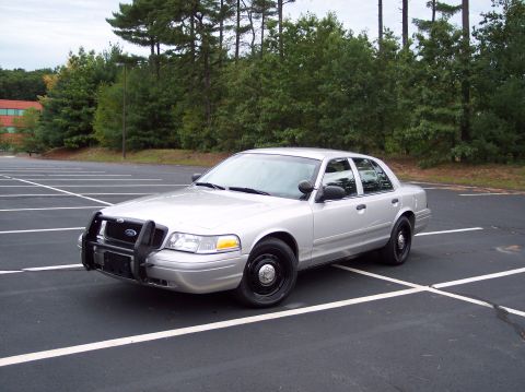 2001 Ford Crown Victoria - This 2001 Ford Crown Victoria, likely a former police vehicle, is seen from a three-quarter front view in a parking lot.