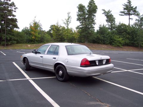 2001 Ford Crown Victoria - This silver 2001 Ford Crown Victoria is seen from the rear three-quarter angle in an empty parking lot.
