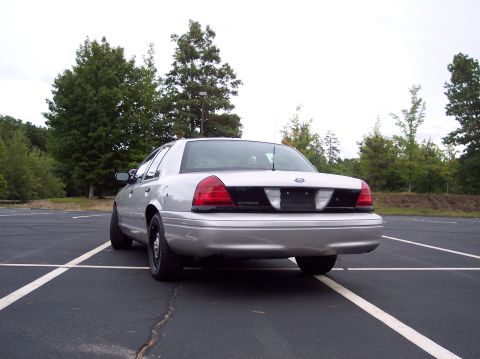 2001 Ford Crown Victoria - Silver 2001 Ford Crown Victoria parked in a lot with trees in the background.