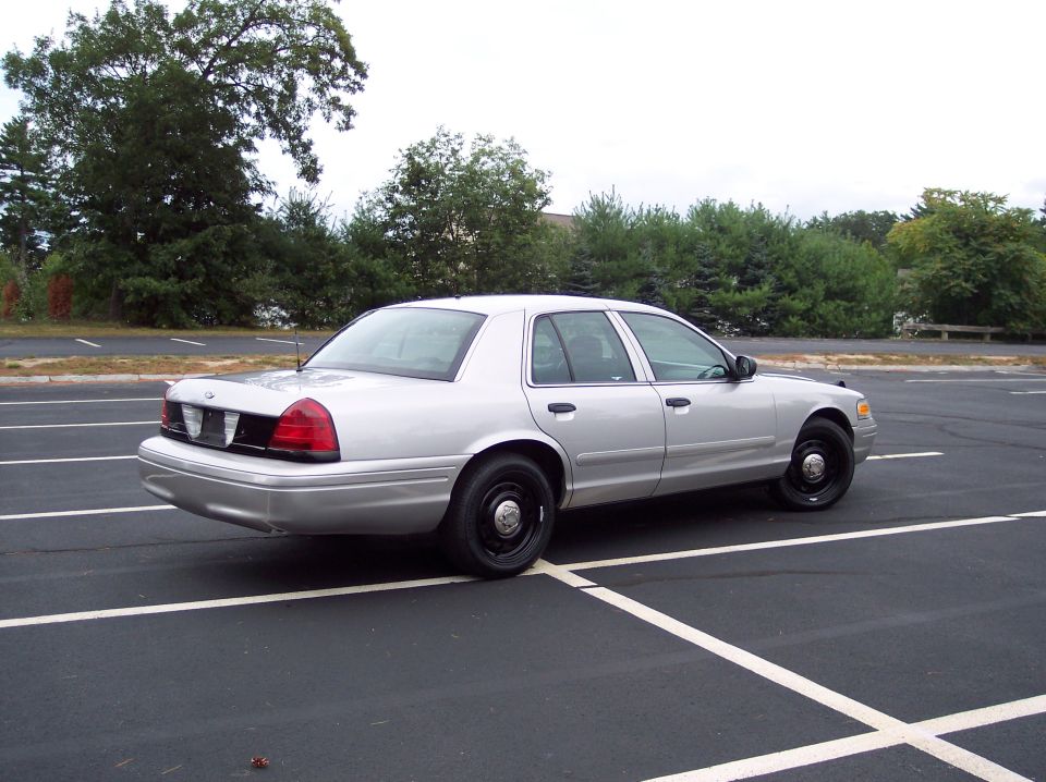 Silver 2001 Ford Crown Victoria parked in a lot, rear quarter view