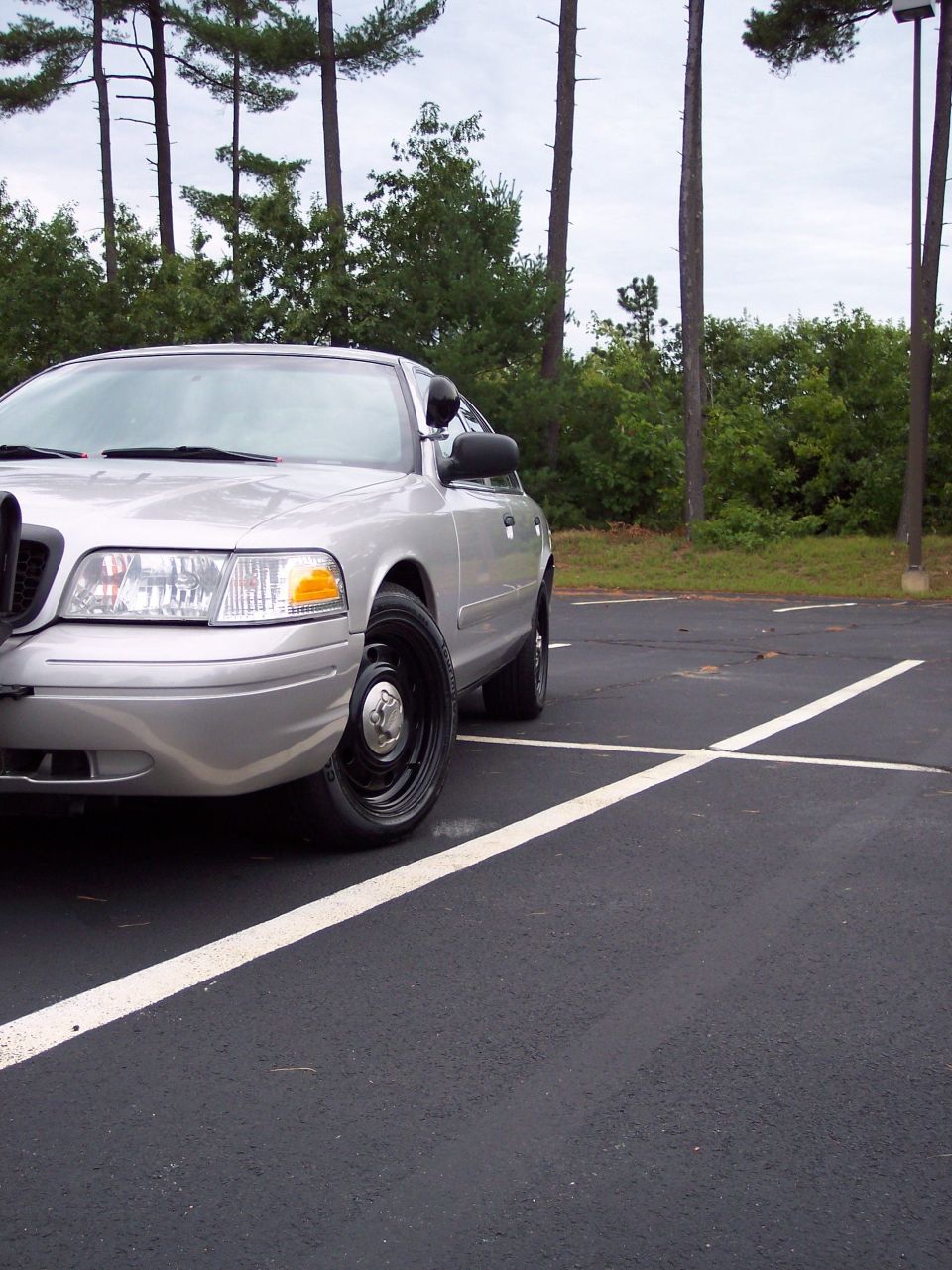 Silver 2001 Ford Crown Victoria police car parked in a lot, front quarter view