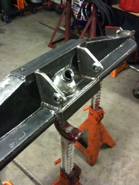 Suzuki Samurai - Custom metal axle housing assembly, likely for off-road use, is held up by industrial jack stands.